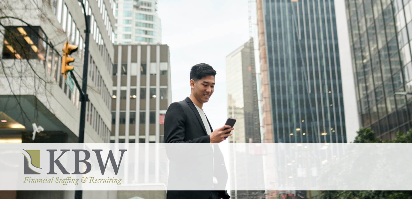 Man holding a phone walking through a city